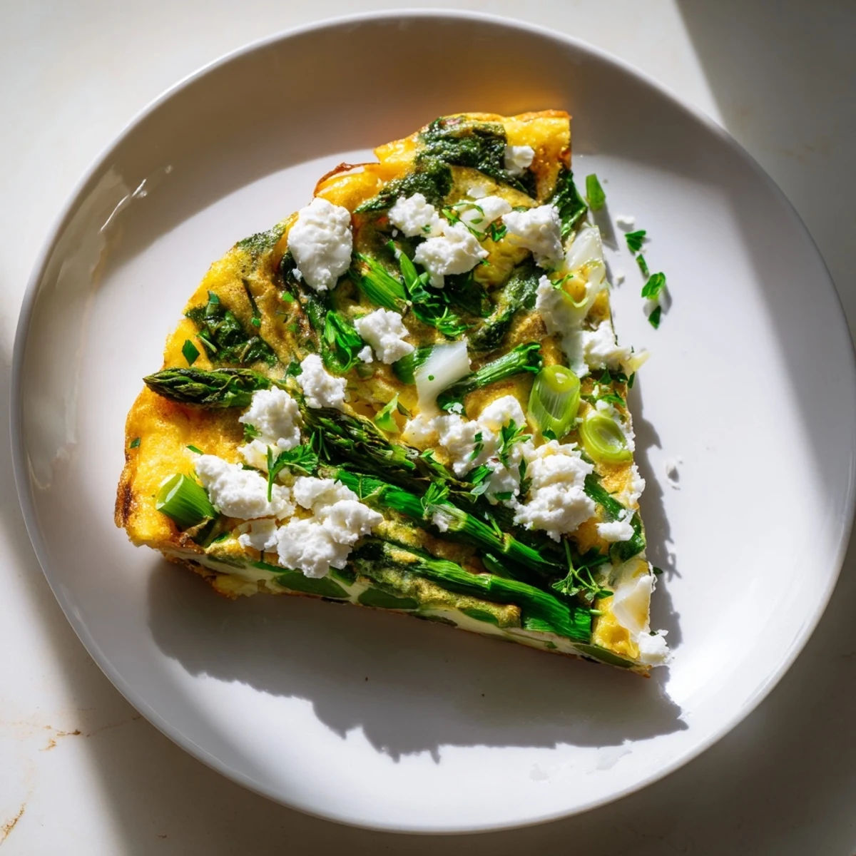 Enjoy the comforting texture and taste of a delicious Frittata with Spring Greens and crumbled goat cheese.