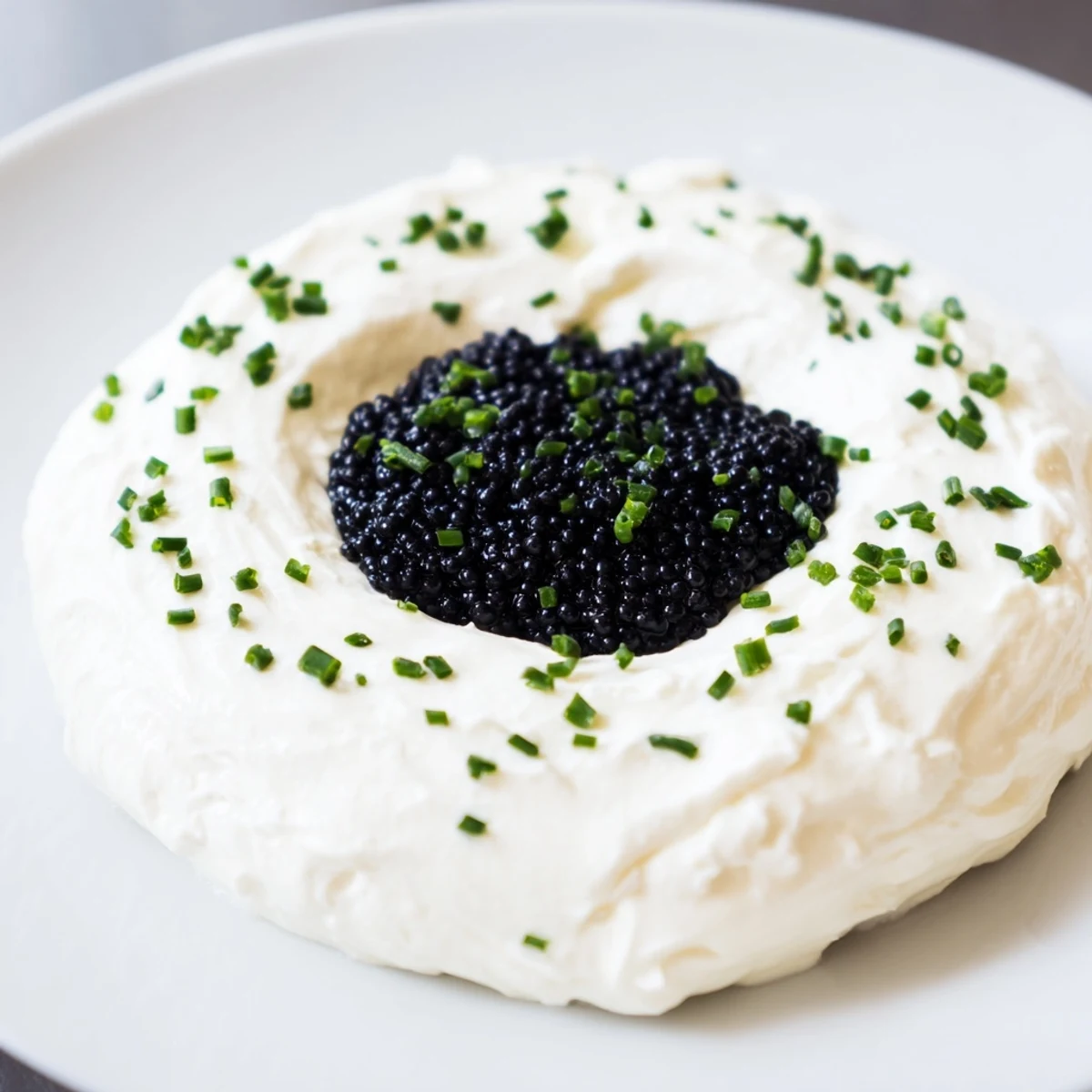 A close-up of The Diamond Inlay appetizer: a creamy ring and luxurious, dark caviar center.