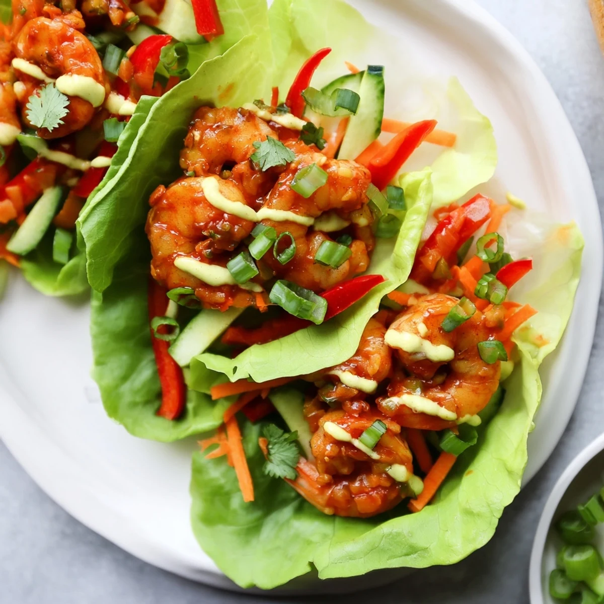 These enticing shrimp lettuce cups showcase perfectly cooked shrimp nestled in crisp lettuce with a tasty sauce drizzle.