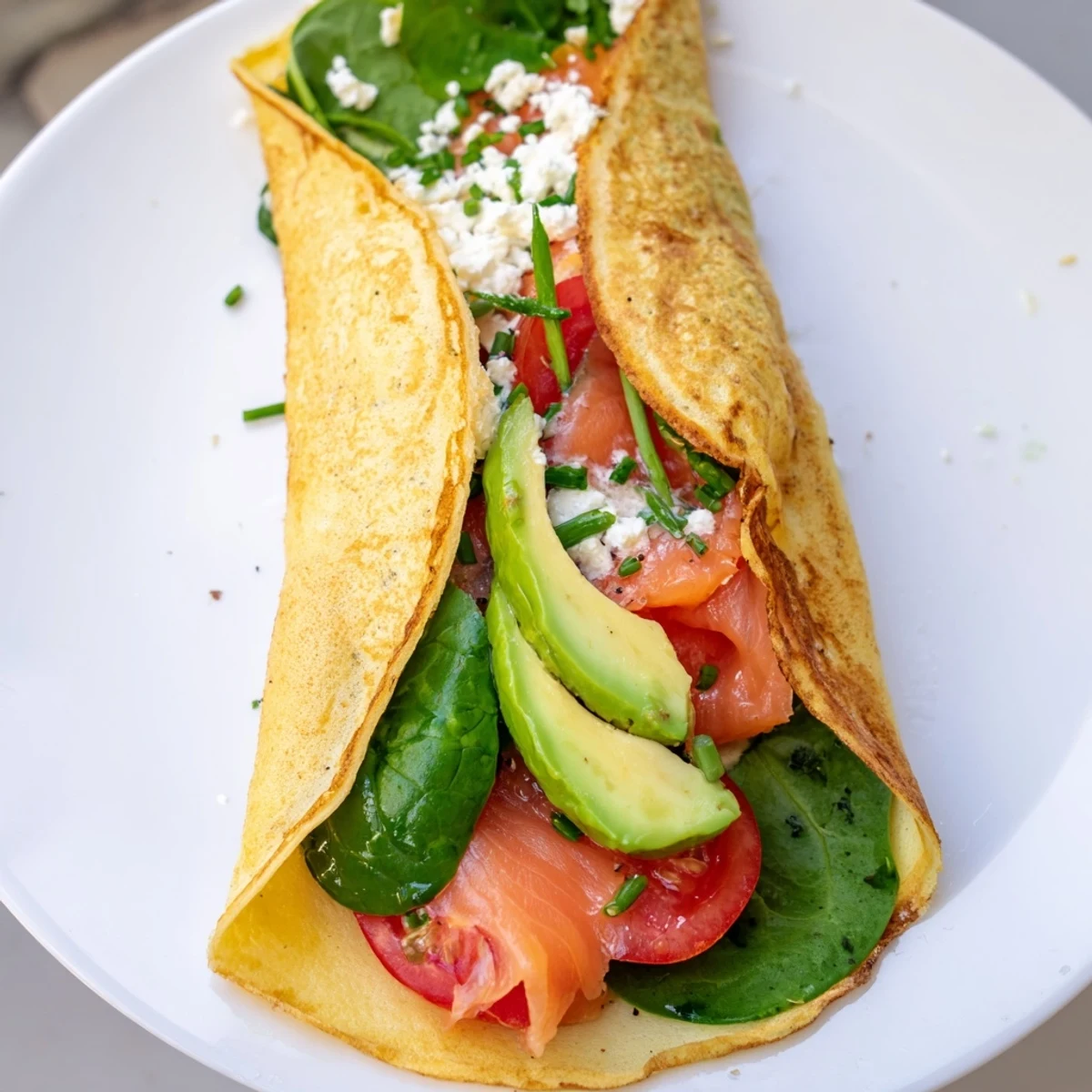 A golden-brown blender egg crepe wrap, ready to slice, overflowing with fresh, vibrant ingredients.