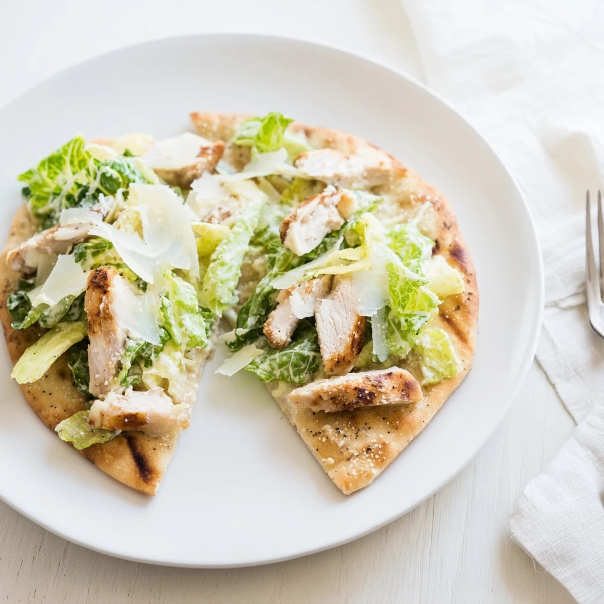 Sliced Chicken Caesar Flatbread on a wooden board, ready for a light lunch or appetizer.