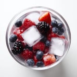 Cool, hydrating Natures Cereal Bowl garnished with fresh strawberries and blueberries served in a glass bowl.  