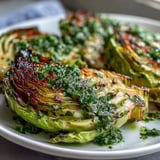 Golden-brown cabbage steaks drizzled with bright, spicy jalapeño chimichurri sauce.