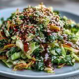 A close-up of Hot and Sour Cabbage, showcasing tender-crisp green leaves and scallions for a flavorful vegan side dish.