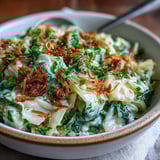 A close-up of fragrant Coconut Braised Cabbage with warm turmeric tones, served alongside fluffy white basmati rice.