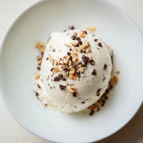 Creamy cottage cheese ice cream, ready to scoop, awaits with optional chocolate chips and freshness.