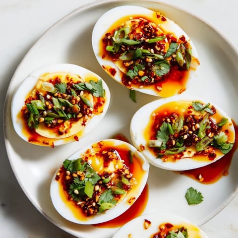 Golden halves of Chili Oil Eggs, topped with sesame seeds, ready for a satisfying bite.