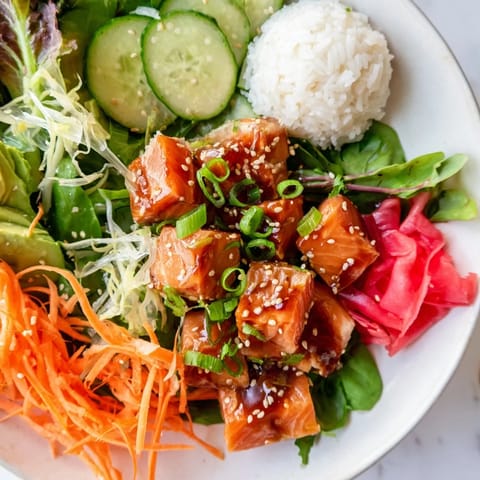 A beautiful photo shows a healthy poke bowl salad garnished with sesame seeds and nori strips.