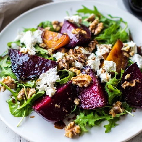 A beautifully plated Beet and Goat Cheese Salad with balsamic glaze and toasted walnuts.