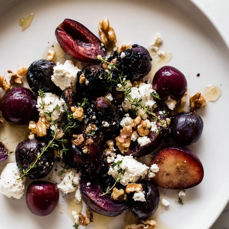 Elegant Midnight Orchard fruit and cheese platter with glistening cherries, plums, and grapes next to the cheese.