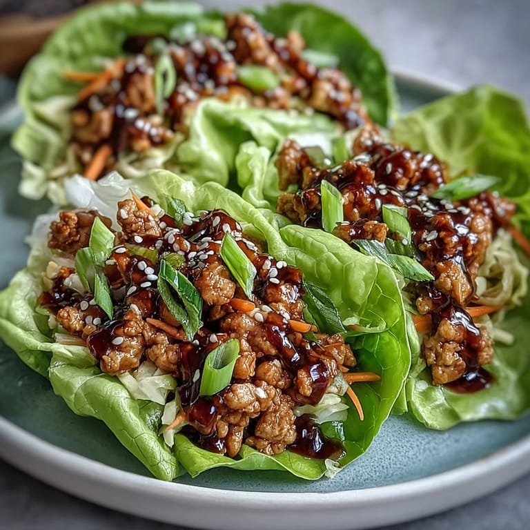 Freshly prepared Potsticker Noodle Lettuce Cups garnished with sesame seeds and scallions on a platter.